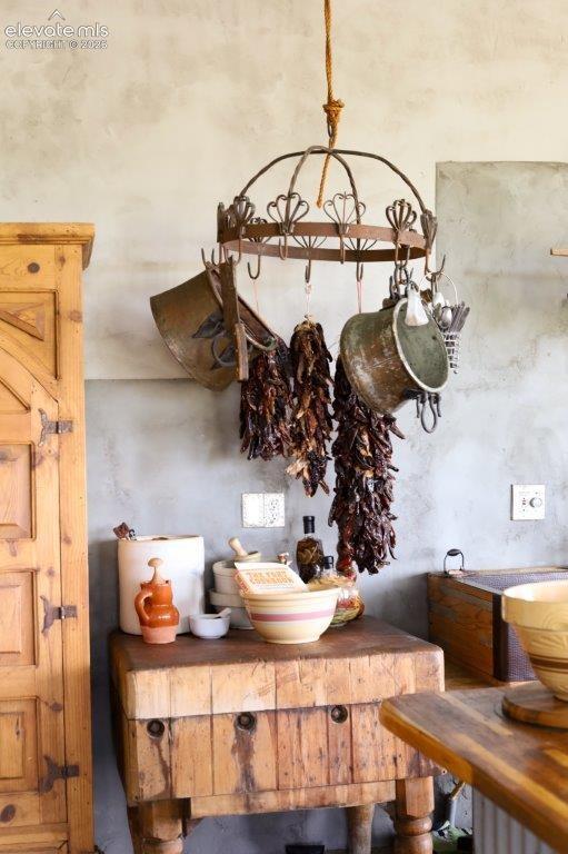 Image 12 of 50: Butcher block island with turned wood legs, featuring a rustic wooden cabin