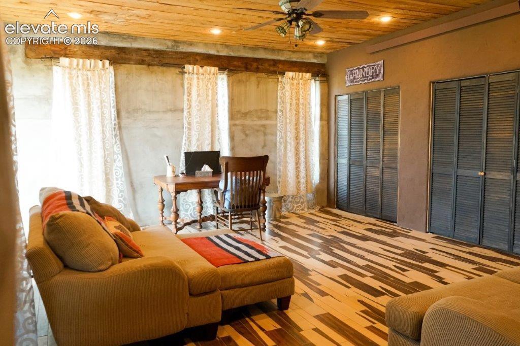 Image 25 of 50: Wood-plank ceiling with recessed lighting and a ceiling fan