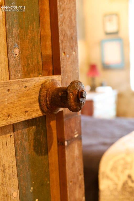 Image 31 of 50: Wooden plank door featuring a rustic metal knob