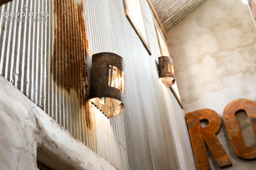 Image 39 of 50: Corrugated metal wall with integrated sconce lighting and decorative metal