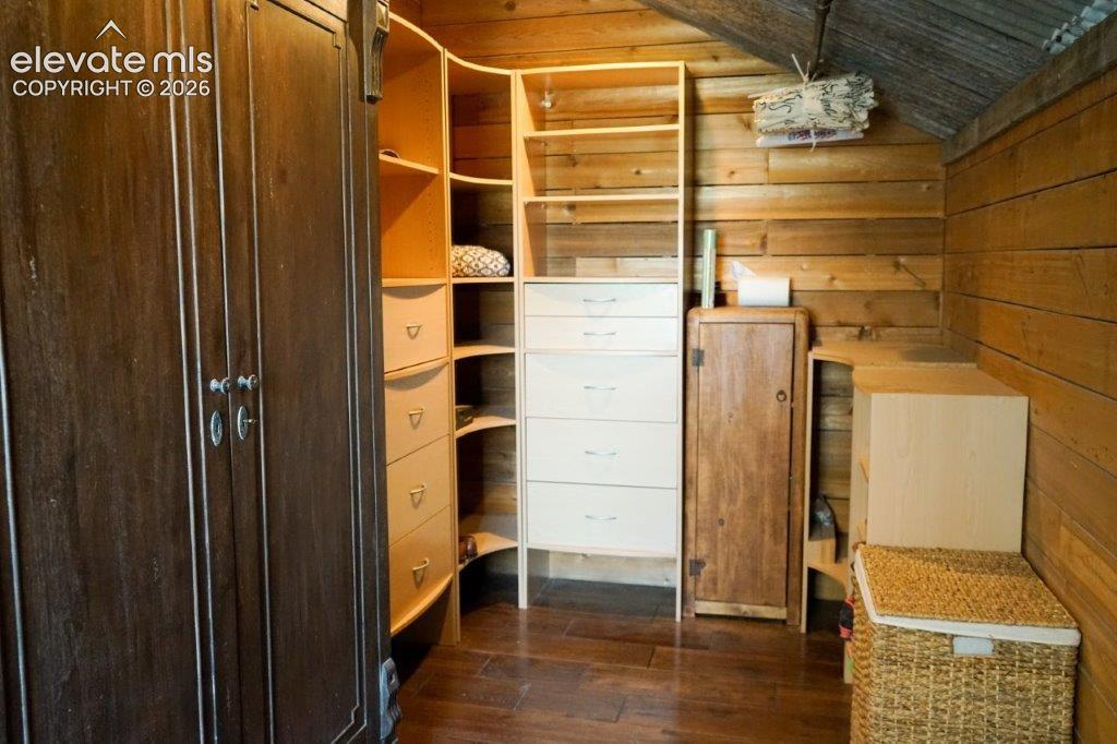Image 47 of 50: Built-in closet system featuring multiple shelves and drawers, dark wood-fi