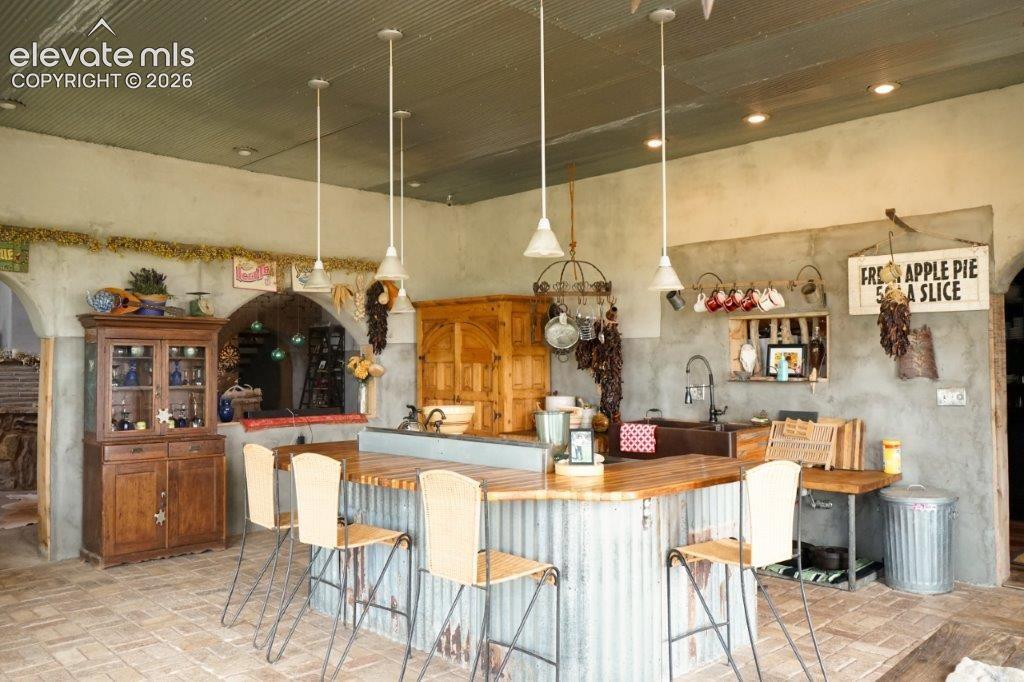 Image 5 of 50: Spacious kitchen featuring a large wood-finish island with corrugated metal