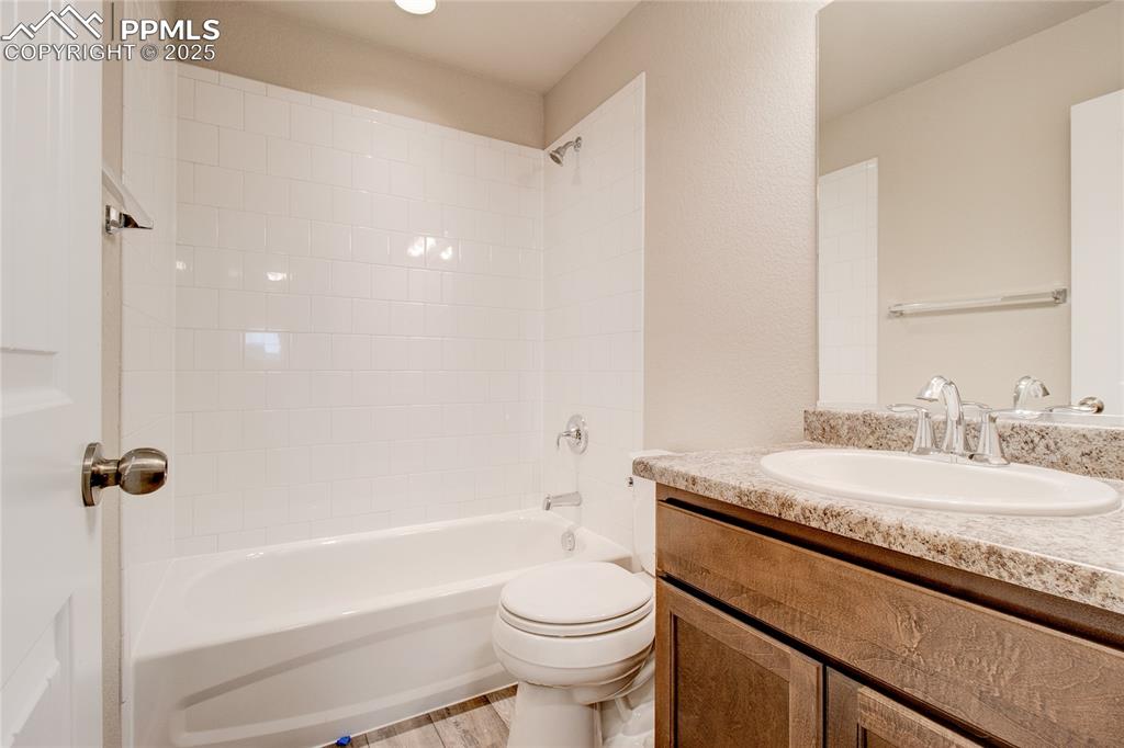 Image 24 of 24: Full bath featuring shower / bathtub combination, vanity, and light wood-st