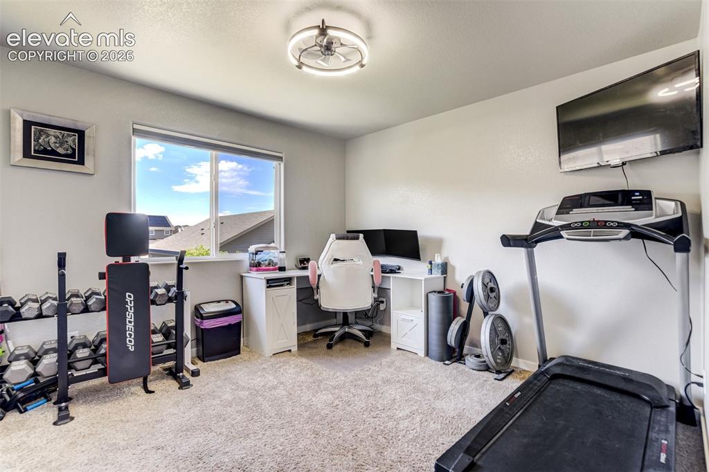 Image 26 of 42: Third upper level bedroom currently used as fitness room.