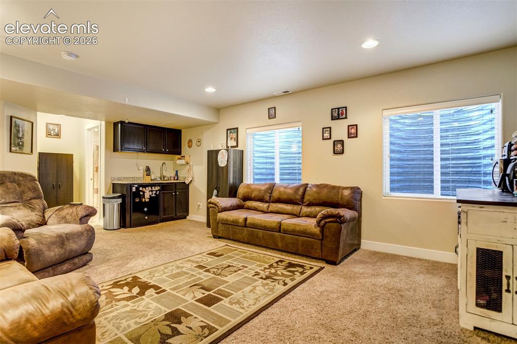 Image 31 of 42: Basement family room with wet bar.