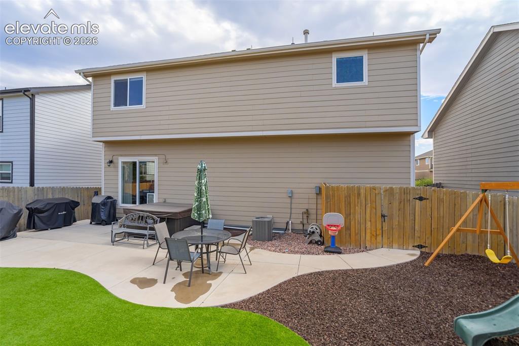 Image 38 of 42: Low maintenance back yard, featuring a large patio, storage shed, hot tub a