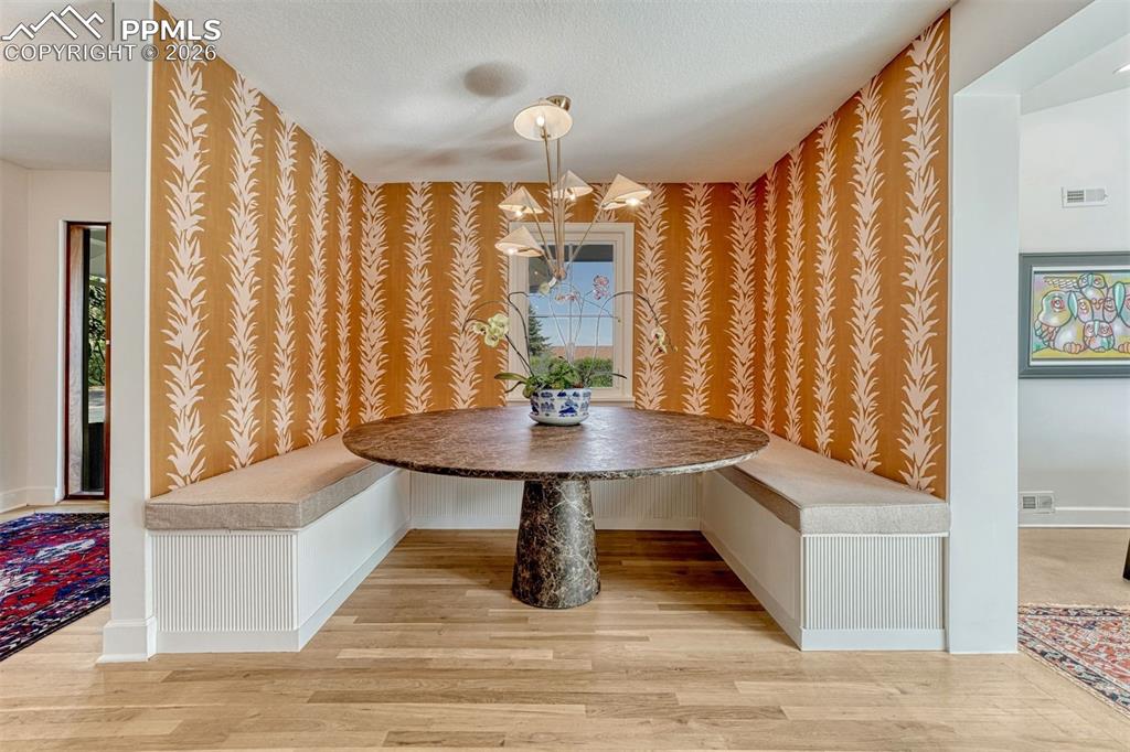Image 13 of 50: An intimate dining nook comes to life with bold wallpaper and a statement l