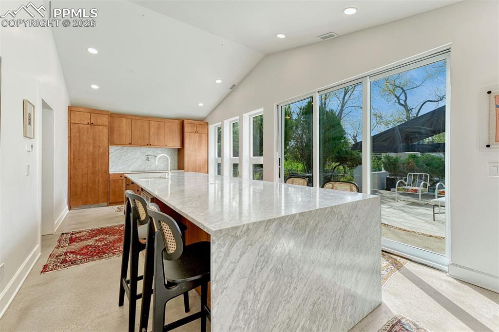 Image 3 of 50: Carrara marble waterfall countertops/backsplash in updated kitchen