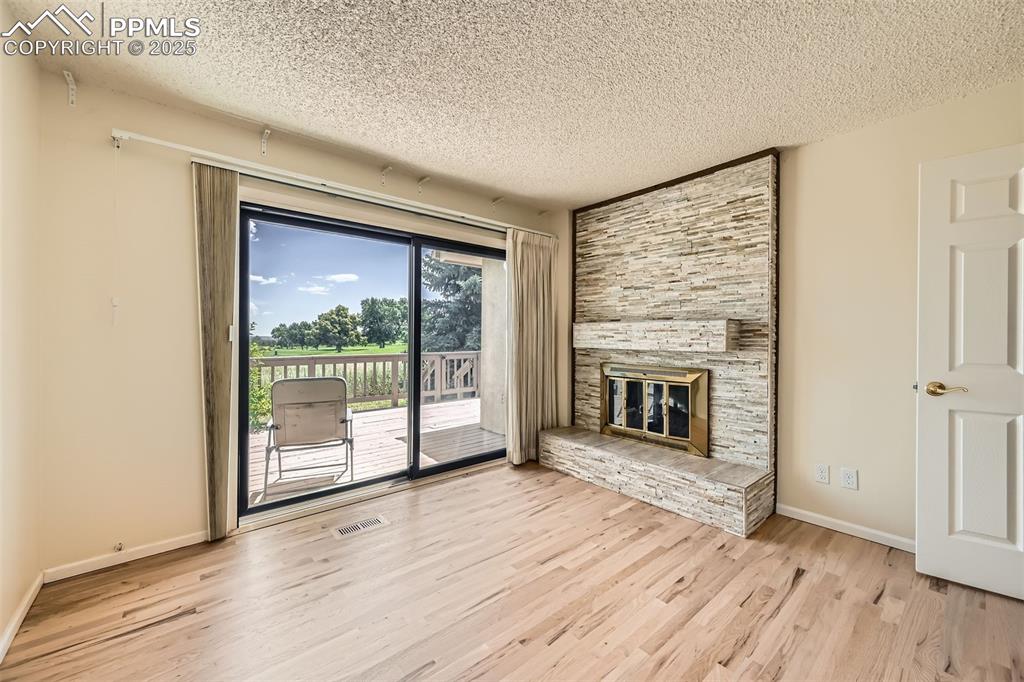 Image 14 of 29: Unfurnished bedroom with a textured ceiling, wood finished floors, and a fi