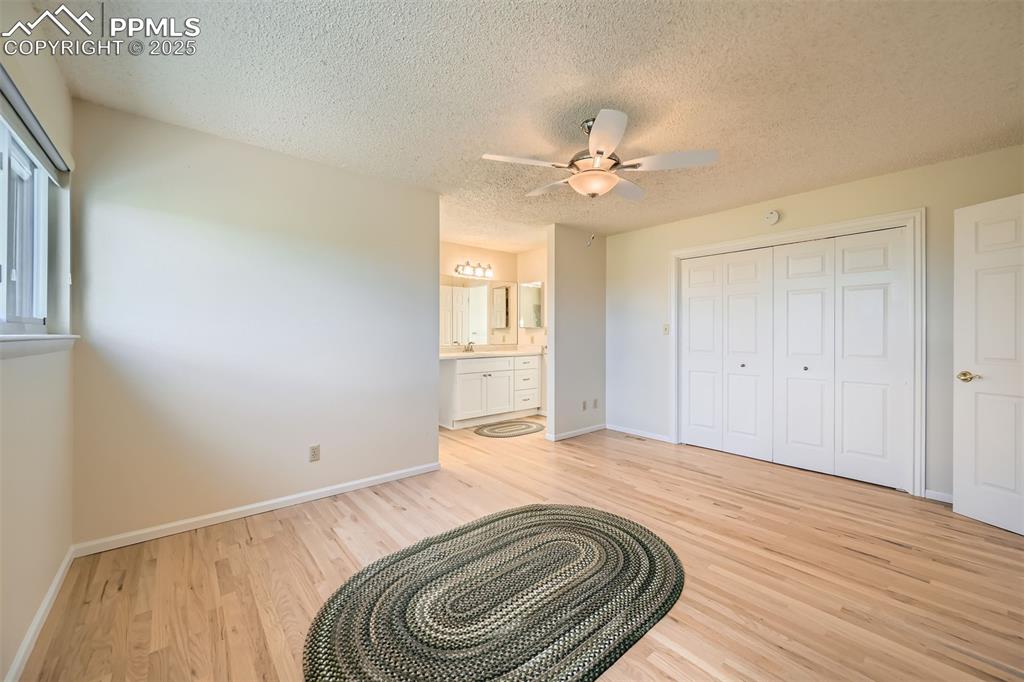 Image 17 of 29: Primary bedroom featuring light wood-style flooring, a textured ceiling, a
