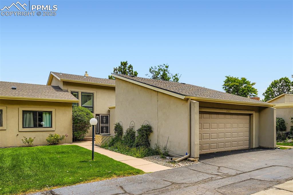 Image 2 of 29: View of front of home with a front lawn, stucco siding, asphalt driveway, a