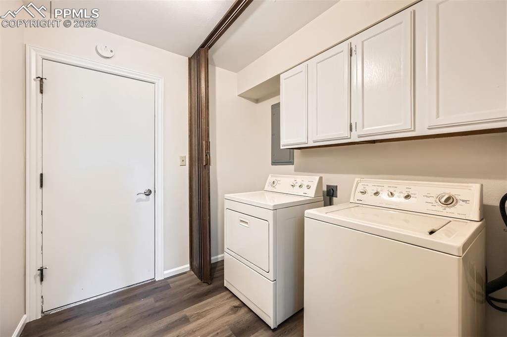Image 25 of 29: Laundry area featuring washer and clothes dryer, wood finished floors, cabi