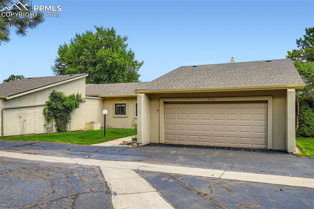 Image 4 of 29: View of front of home with stucco siding and an attached garage