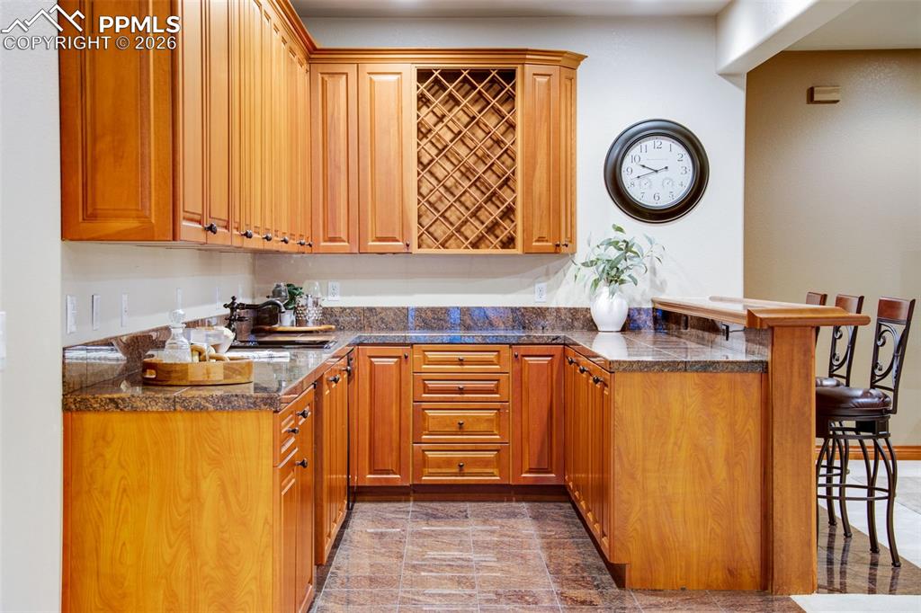 Image 28 of 42: Bar area in the basement level complete with dishwasher and mini fridge 