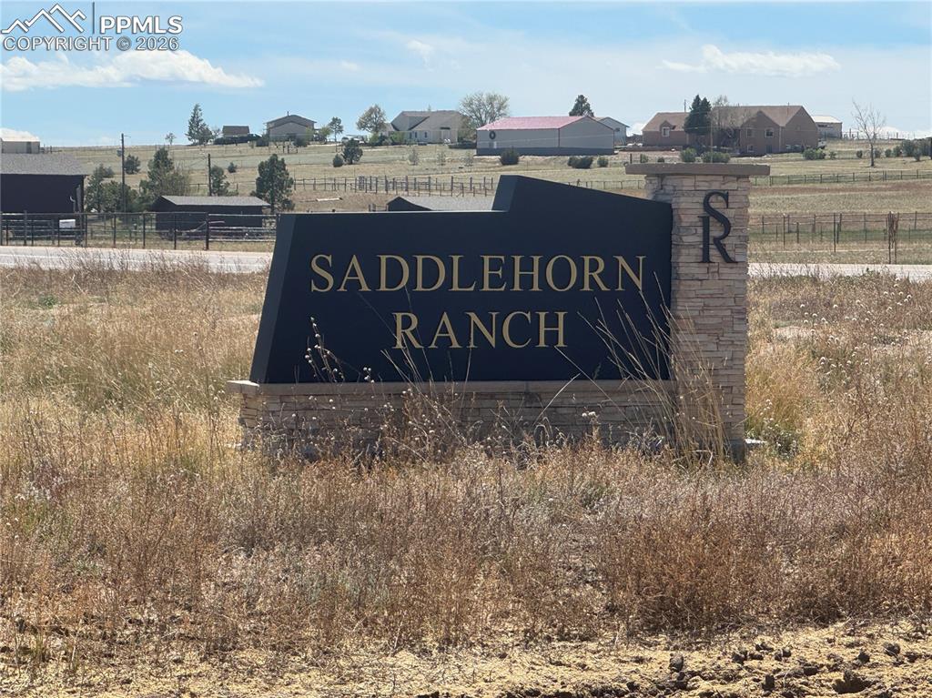 Image 3 of 9: The community entrance features a stone and dark-paneled sign with the comm