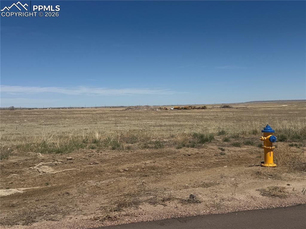 Image 8 of 9: The property features expansive undeveloped land with natural grasses under