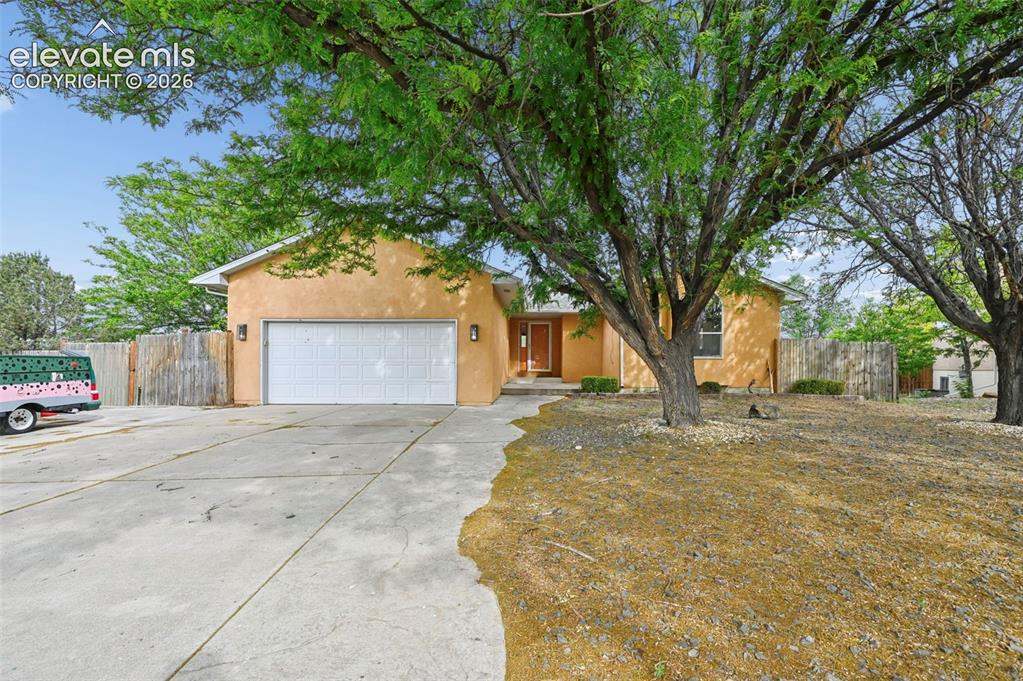 Image 1 of 33: Front exterior with stucco finish and an attached garage