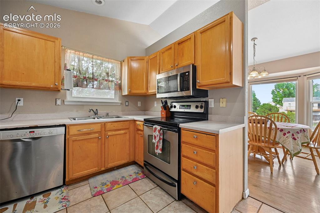 Image 2 of 32: Kitchen featuring wood cabinetry, stainless steel appliances, a double basi