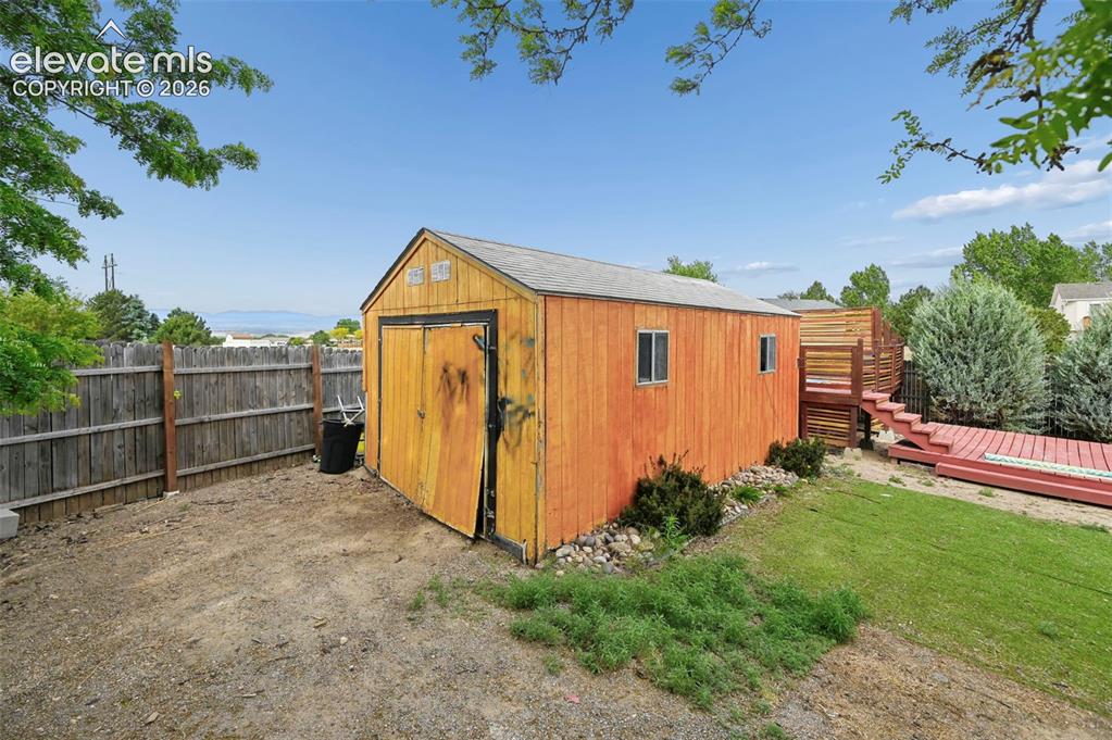 Image 24 of 33: Backyard featuring a detached storage shed with double doors and dual windo