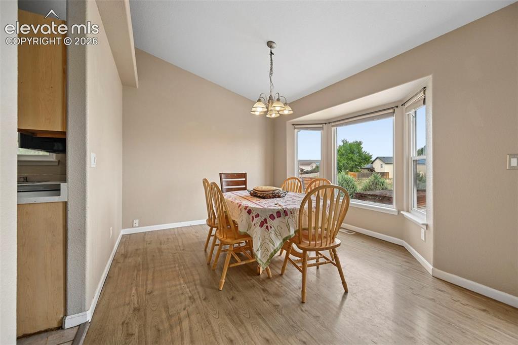 Image 3 of 32: Dining area featuring wood-finish flooring and a bay window
