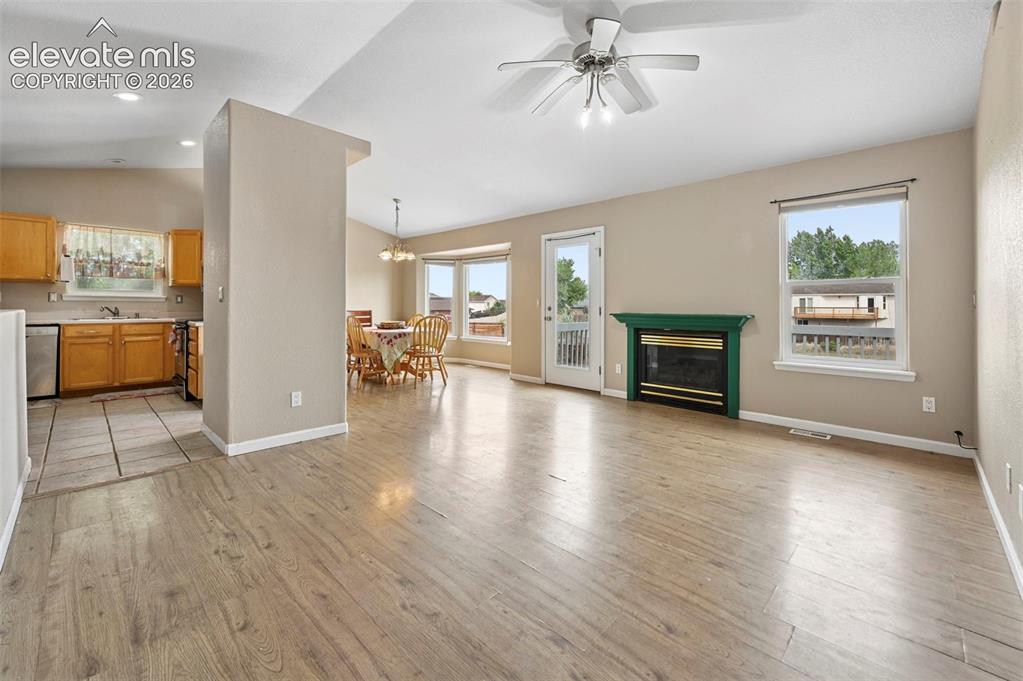 Image 5 of 33: Open-concept living space featuring wood-finish flooring, a ceiling fan wit