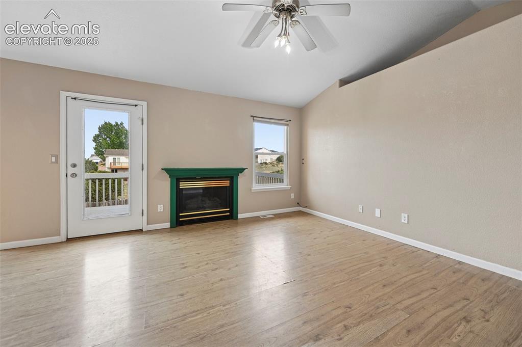 Image 6 of 33: Spacious room featuring light wood-finish flooring, a decorative fireplace