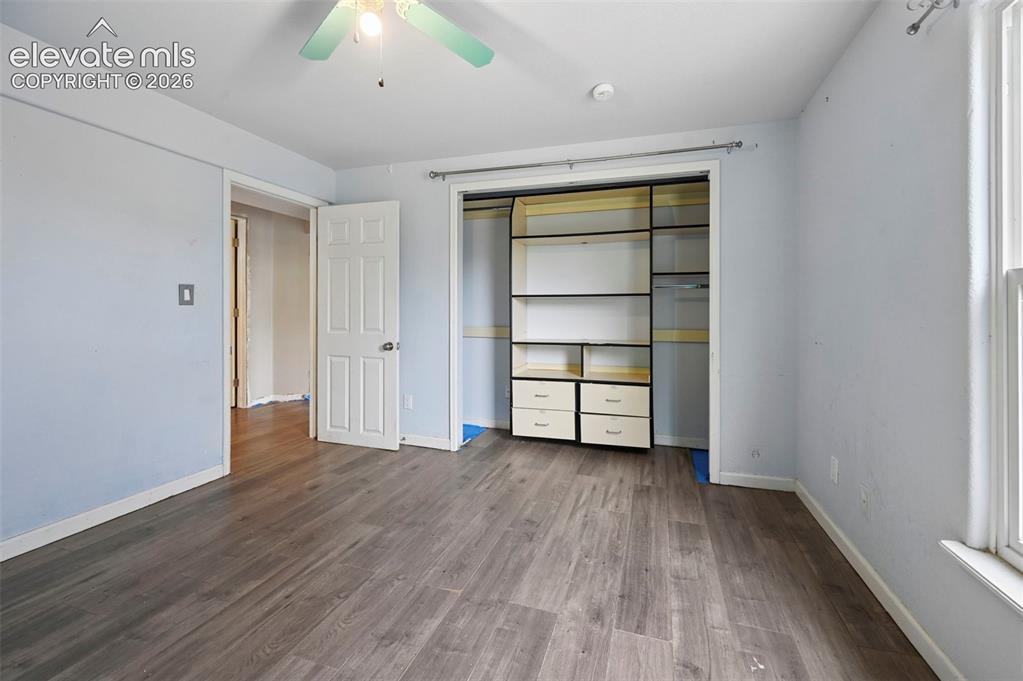 Image 8 of 32: Room featuring wood-finish flooring, a ceiling fan with light fixture, and