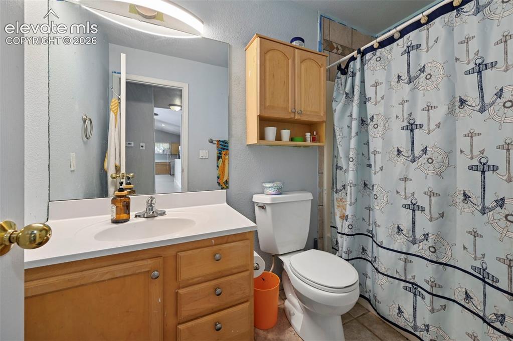 Image 9 of 32: Bathroom vanity with a white countertop and integrated sink, chrome faucet,
