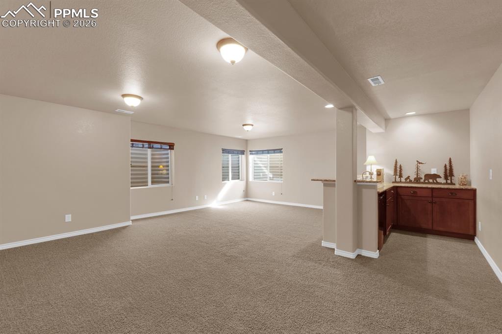 Image 22 of 33: Family room with wet bar
