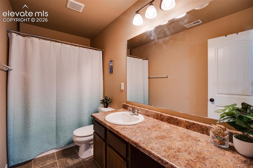 Image 26 of 37: Upper Level Full Bathroom with a tile floor, extended vanity, mirror, and t