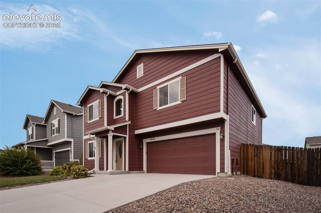 Image 4 of 37: 2-car attached garage and xeriscaped side yard with rock bed.