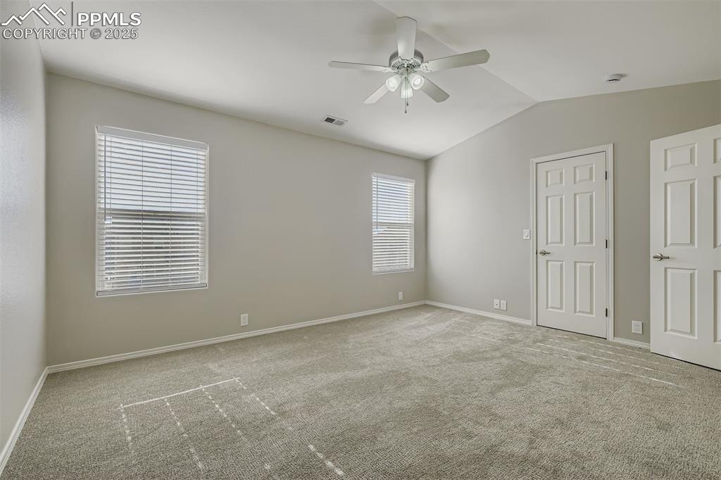 Image 10 of 22: Unfurnished bedroom featuring light colored carpet, vaulted ceiling, and a 
