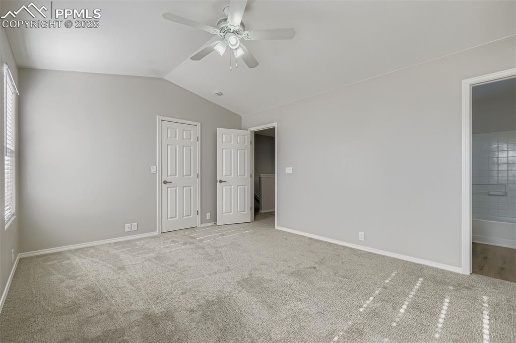 Image 11 of 22: Unfurnished bedroom featuring vaulted ceiling, ceiling fan, carpet floors, 
