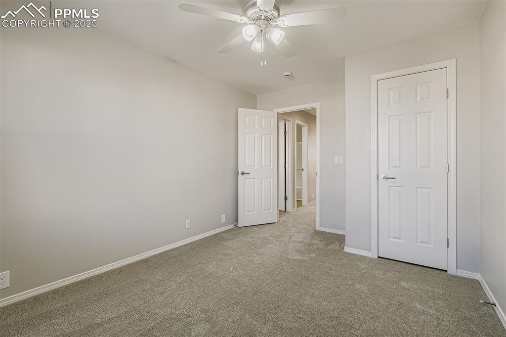 Image 18 of 22: Unfurnished bedroom with carpet floors and a ceiling fan