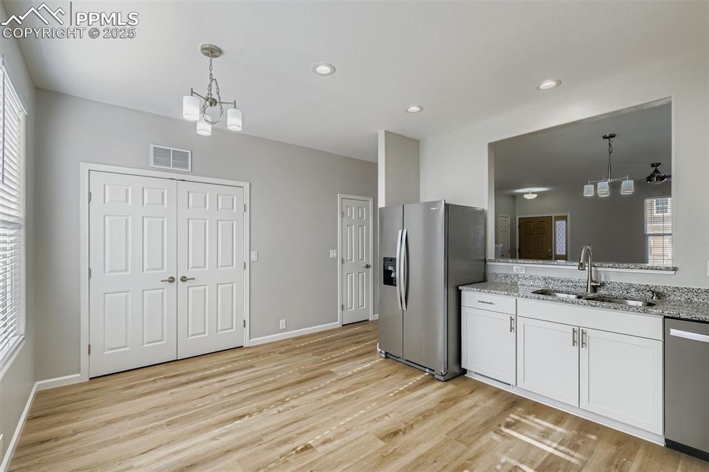 Image 7 of 22: Kitchen with a chandelier, decorative light fixtures, stainless steel appli