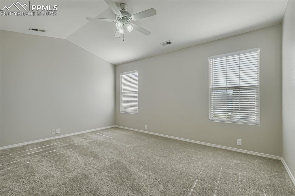 Image 9 of 22: Unfurnished room with carpet flooring, lofted ceiling, and ceiling fan