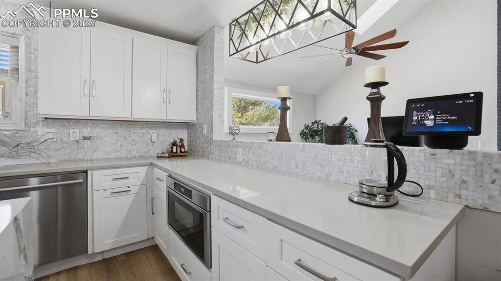 Image 14 of 50: The Kitchen boasts a breakfast bar for informal dining and conversations wi