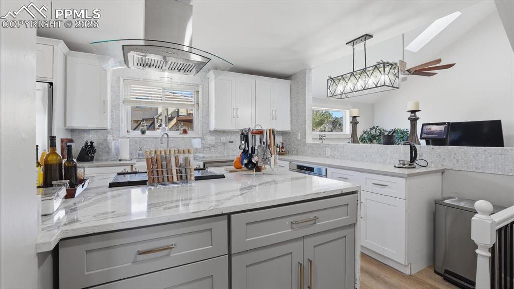 Image 15 of 50: Appliances include a smooth cooktop, vent hood, dishwasher, microwave, oven