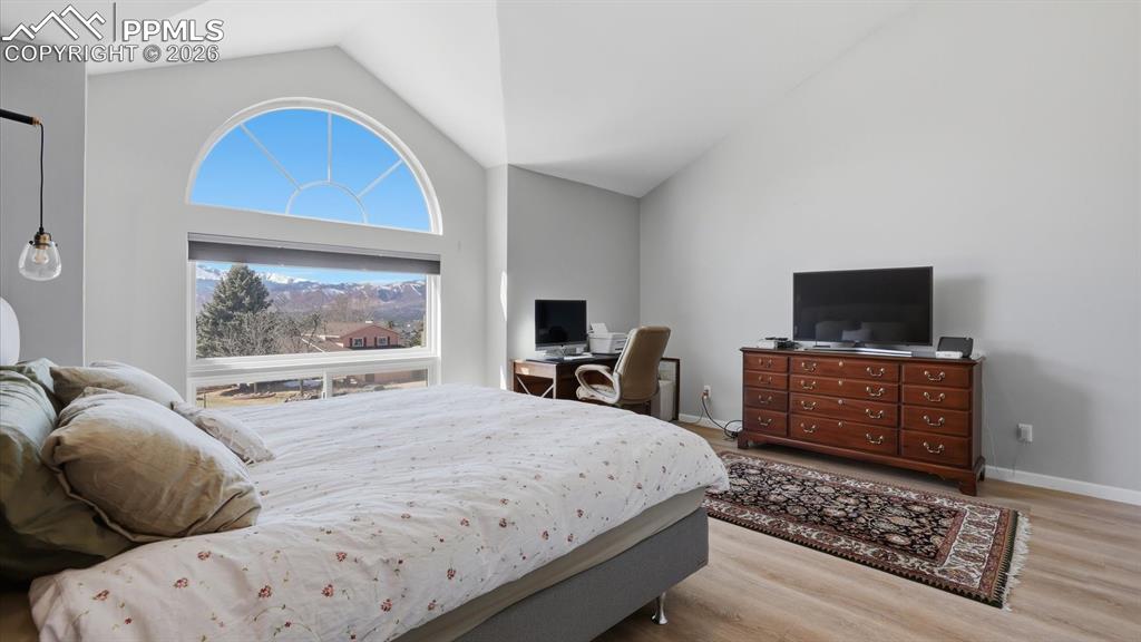 Image 23 of 50: The upper level Primary Bedroom has a vaulted ceiling, LVP flooring, accent