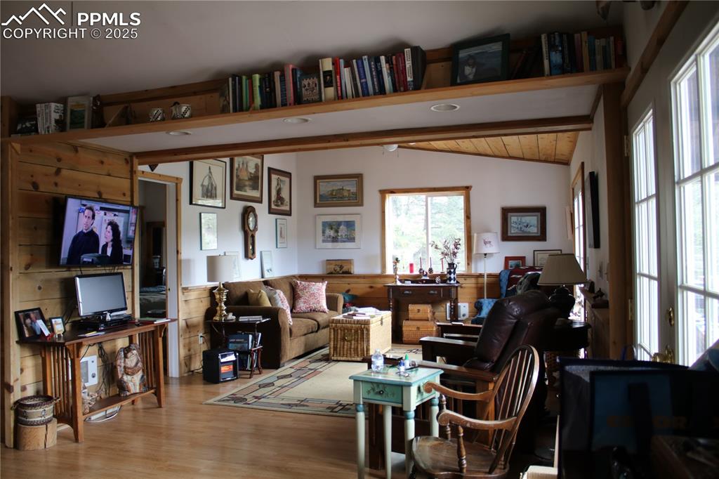 Image 5 of 15: Living area featuring vaulted ceiling and wood finished floors