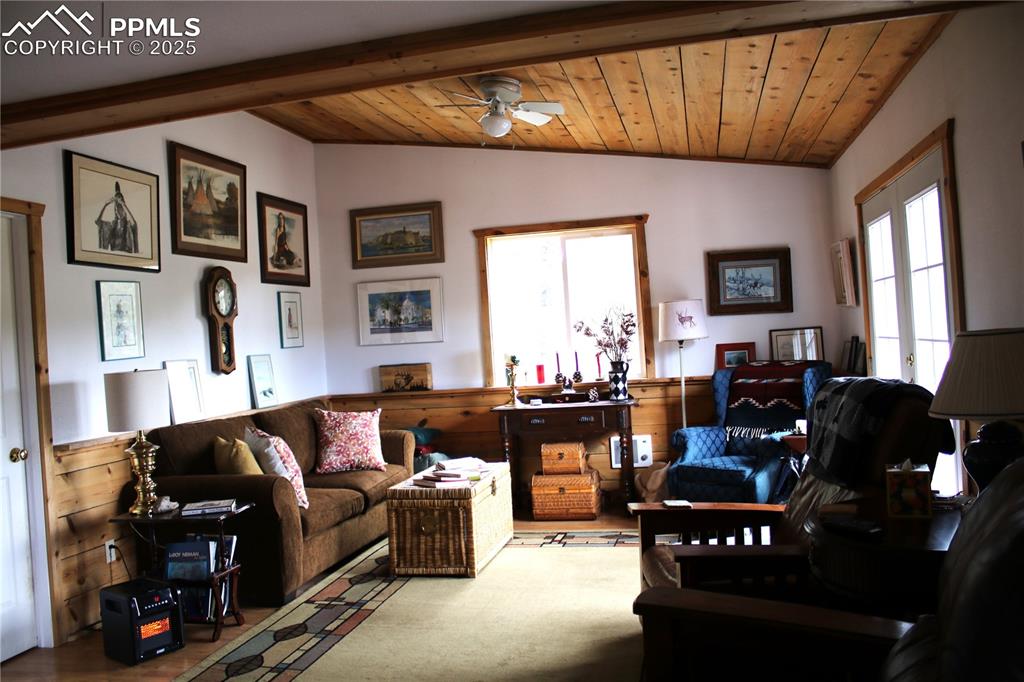 Image 6 of 15: Living room featuring a ceiling fan and wood ceiling