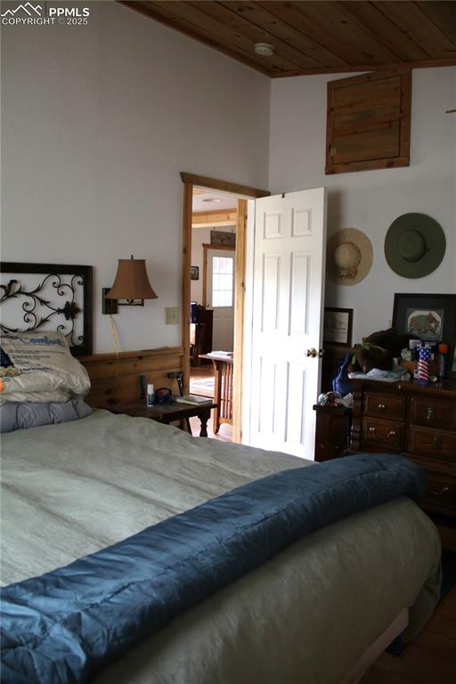 Image 8 of 15: Bedroom with wood ceiling and wainscoting