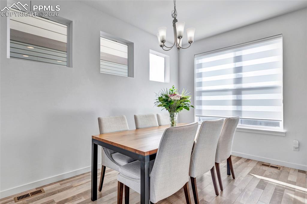 Image 4 of 39: Dining area - LVP flooring, Zebra window coverings
