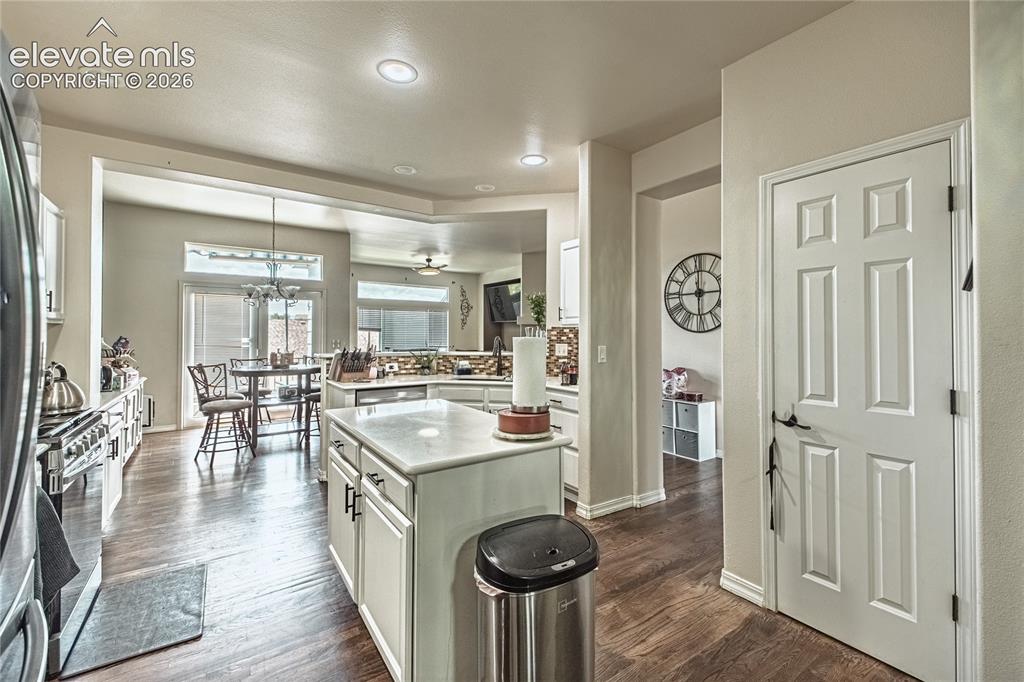 Image 10 of 48: Kitchen featuring wood-finish flooring, recessed lighting, white cabinetry,