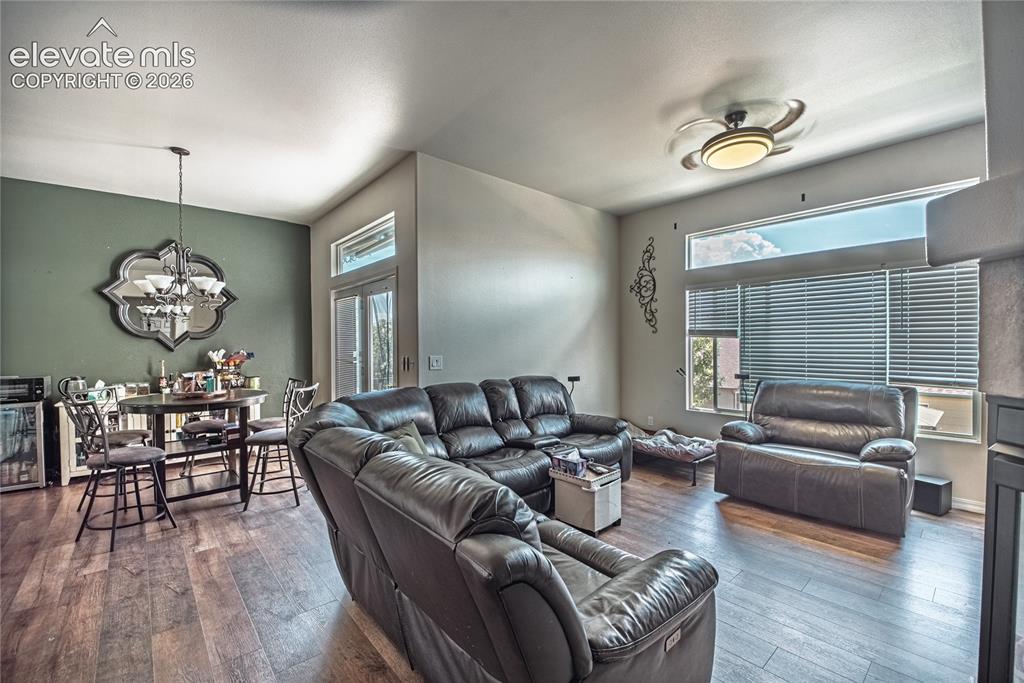 Image 16 of 48: Spacious common area featuring wood-finish flooring, vaulted ceilings, and