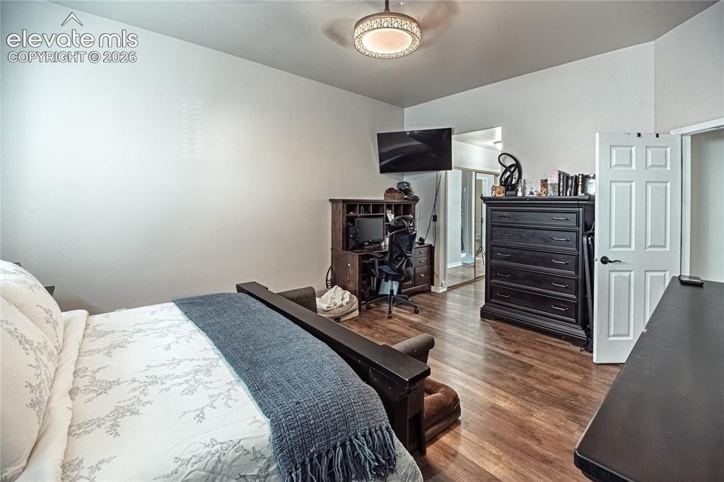 Image 22 of 48: Bedroom featuring wood-finish flooring, a contemporary ceiling fan, and a n