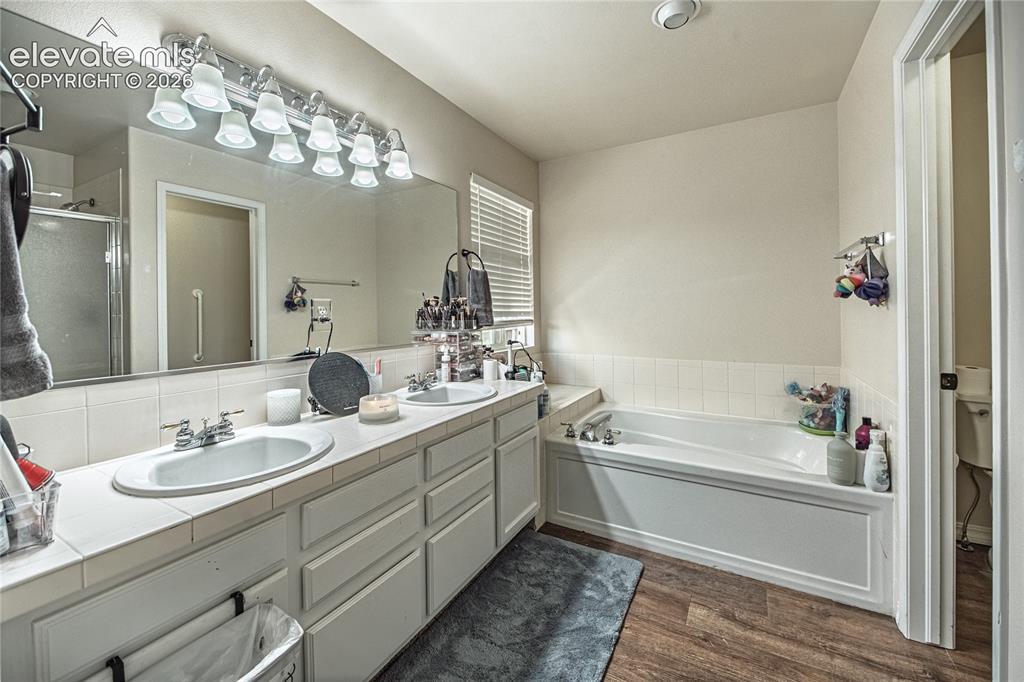 Image 24 of 48: Bathroom featuring a dual vanity with white tile countertop, built-in soaki