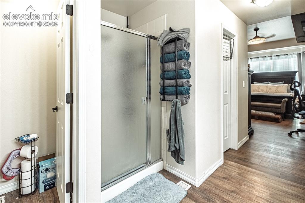 Image 26 of 48: Shower enclosure with frosted glass door, white tile surround, and adjacent