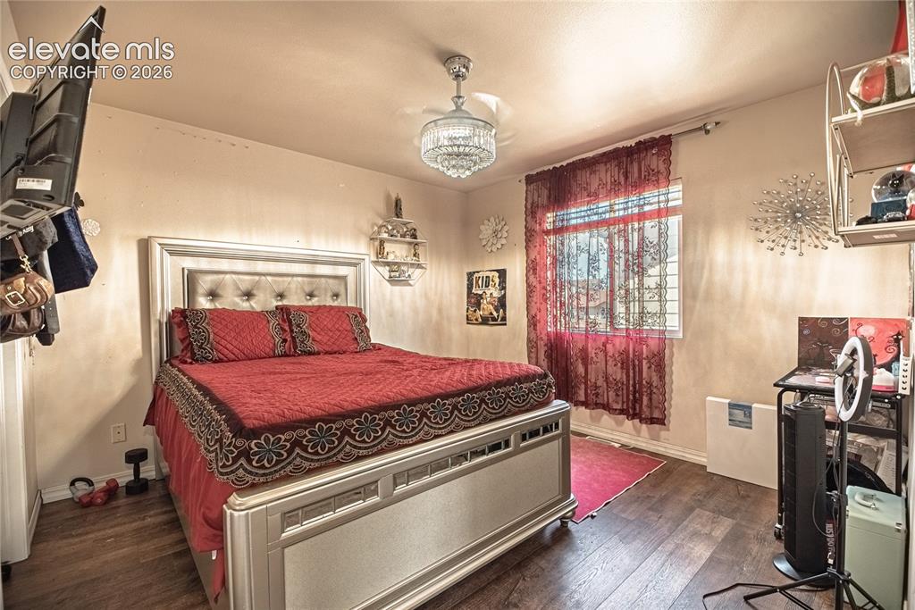 Image 29 of 48: Interior room featuring wood-finish flooring, a single window with curtain