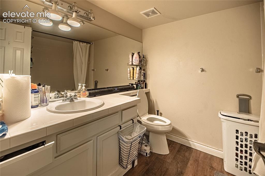 Image 33 of 48: Bathroom featuring a white vanity with an integrated sink, a large mirror,